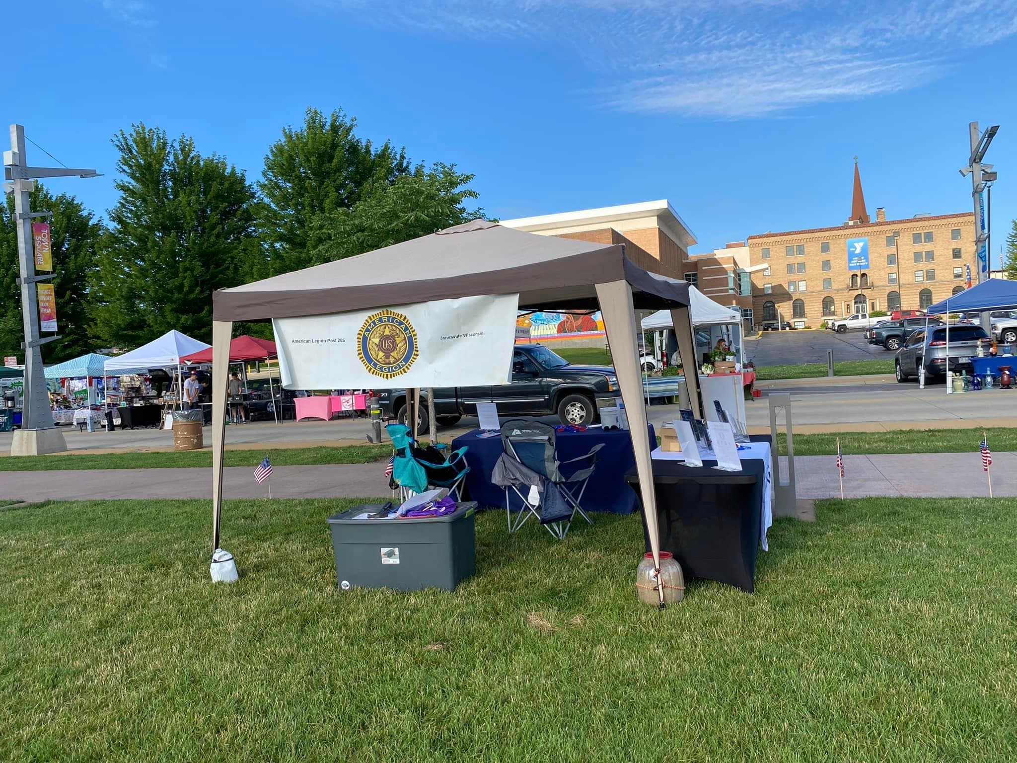 Post 205 tent setup at community event with American Legion emblem banner