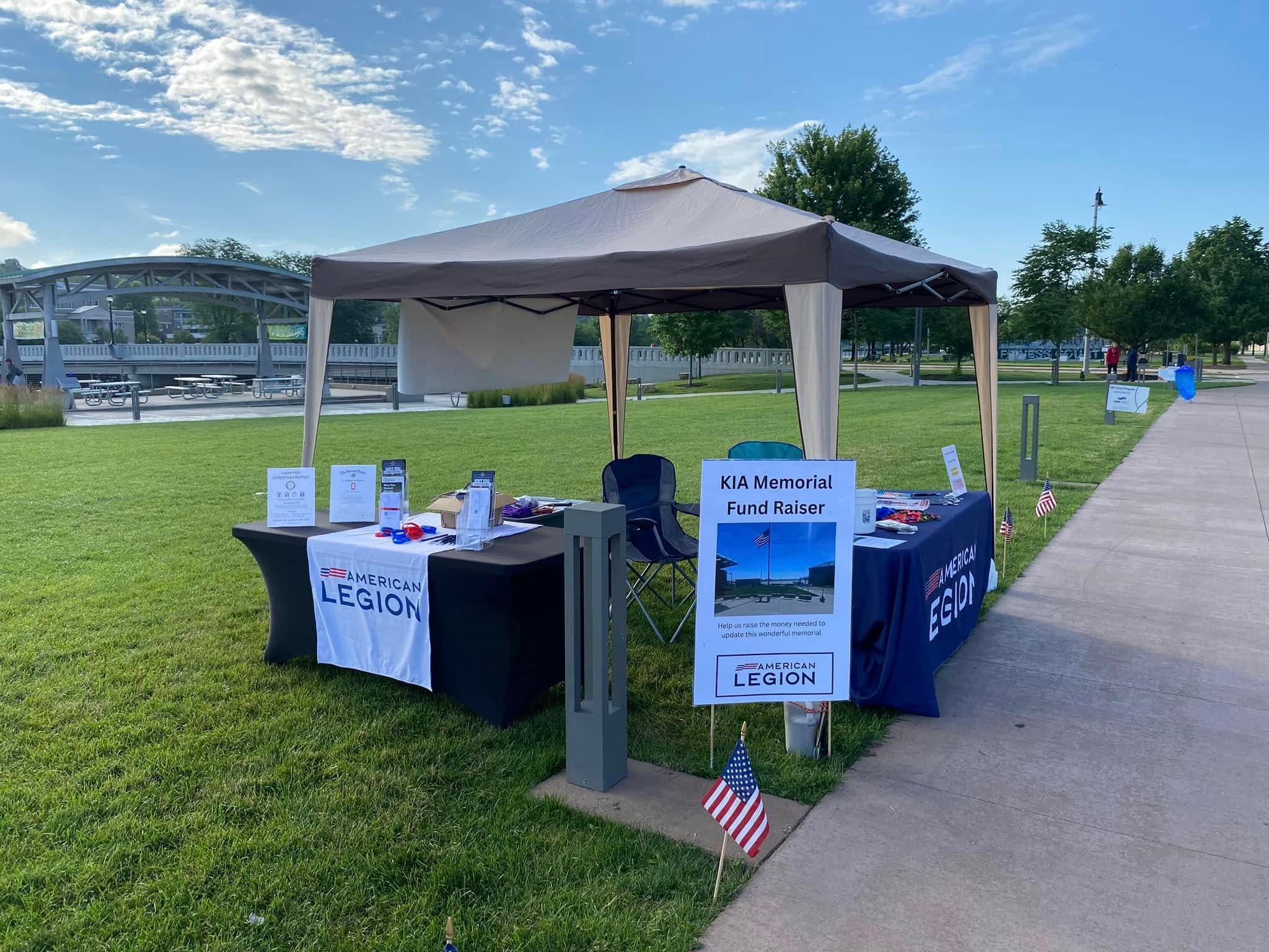 Post 205 booth with KIA Memorial Fund Raiser sign by the river